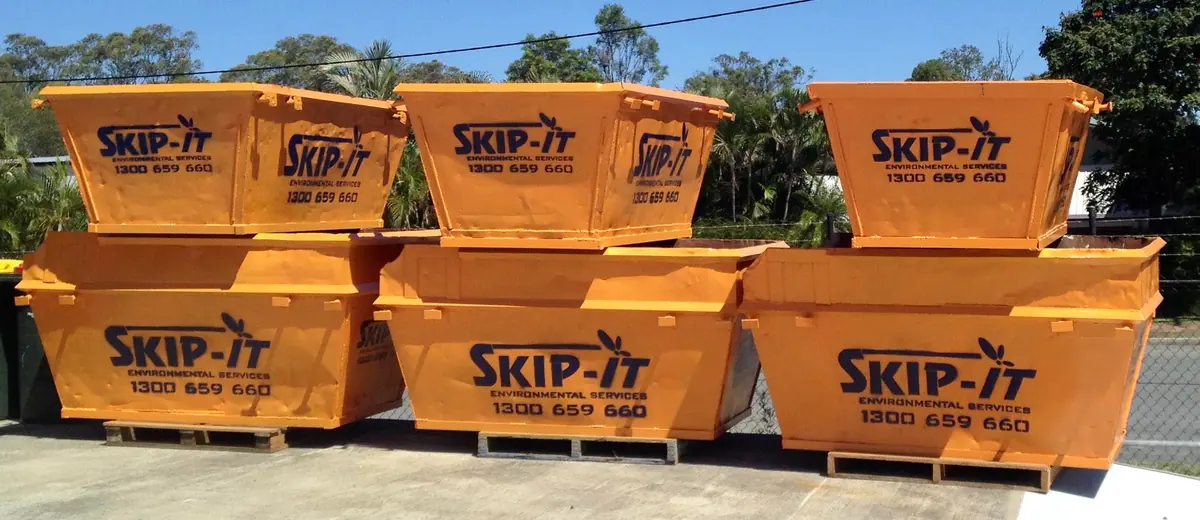 Orange Skip-It bins stacked at the yard